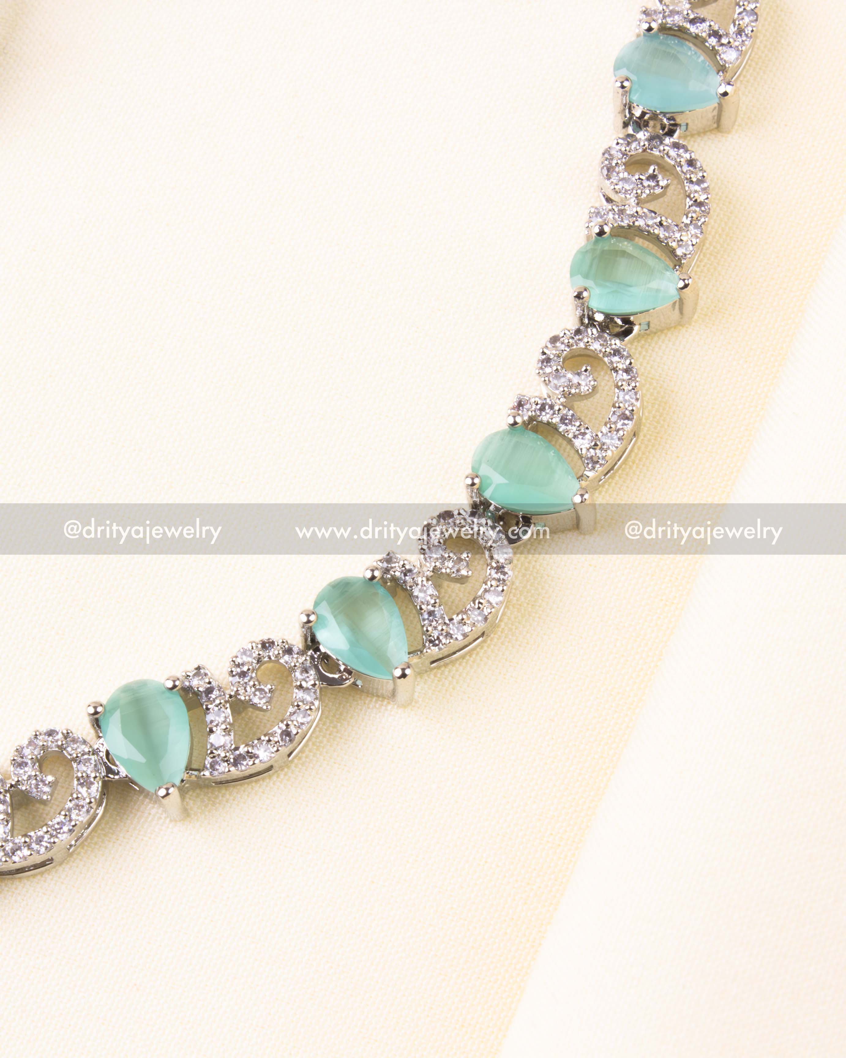 Aqua gemstone necklace with spiral CZ design and teardrop stones in silver finish.