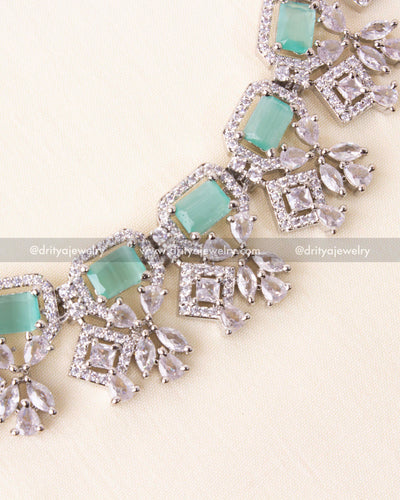 Detailed view of mint blue rectangular stones and crystal droplets in zircon setting.