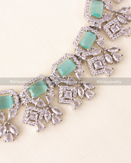 Detailed view of mint blue rectangular stones and crystal droplets in zircon setting.