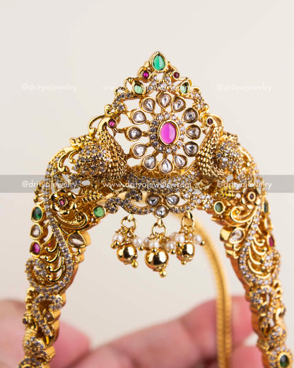 Detailed polki floral motif with ruby and emerald stones in a gold finish.