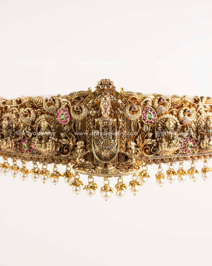 "Intricate Lord Venkateshwara carving with pink, green, and white stones in Nakshi style.