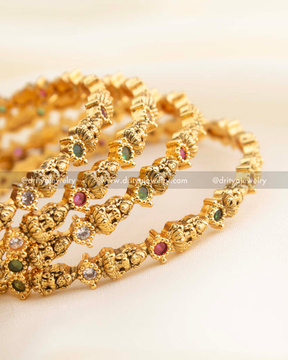 Intricately designed Lakshmi bangles with CZ stones and antique gold polish.