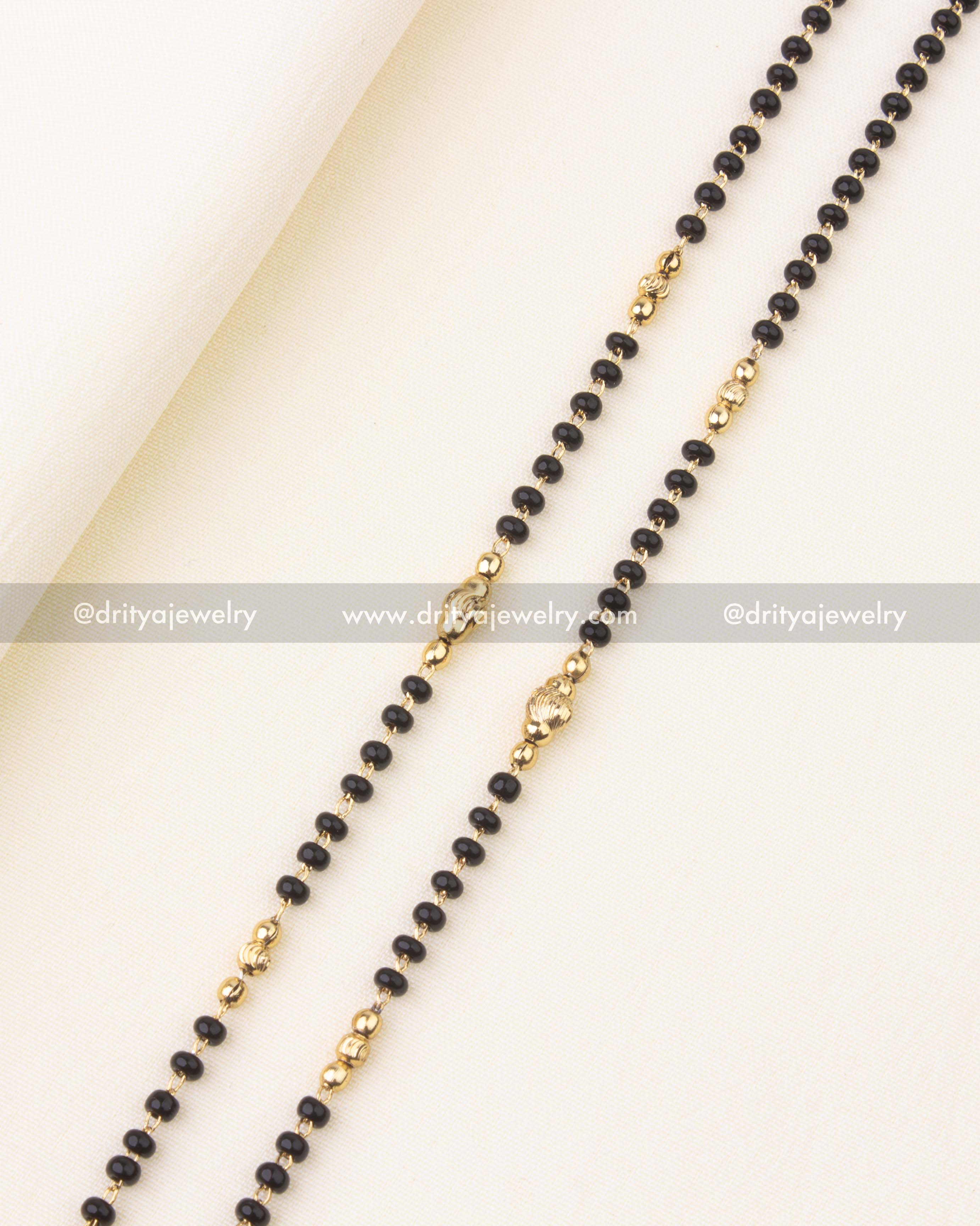 Close-up of antique finish Lakshmi pendant with nakshi detailing and pearl drop.
