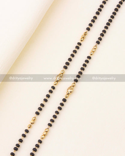 Close-up of antique finish Lakshmi pendant with nakshi detailing and pearl drop.