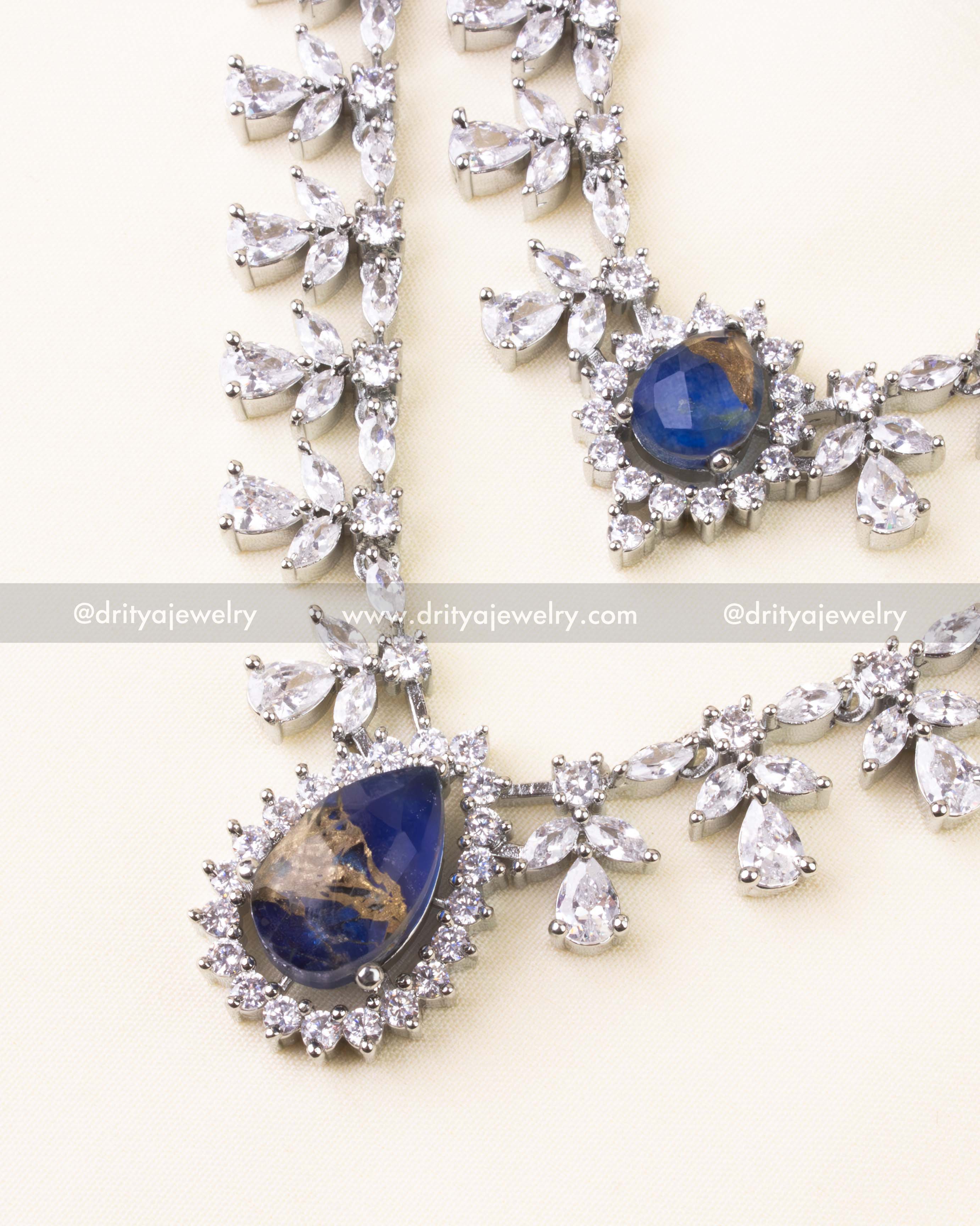 Royal blue teardrop pendant with surrounding CZ sparkle on layered necklace.