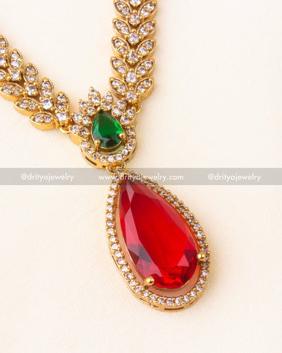 Zoomed view of ruby red pendant surrounded by CZ stones and an emerald green top accent.
