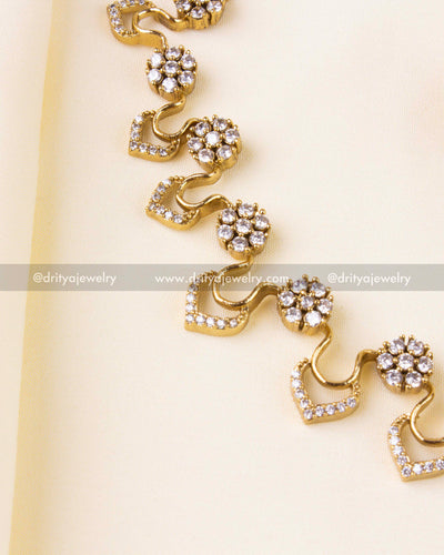 Detailed floral motifs and chevron stone pattern in gold finish