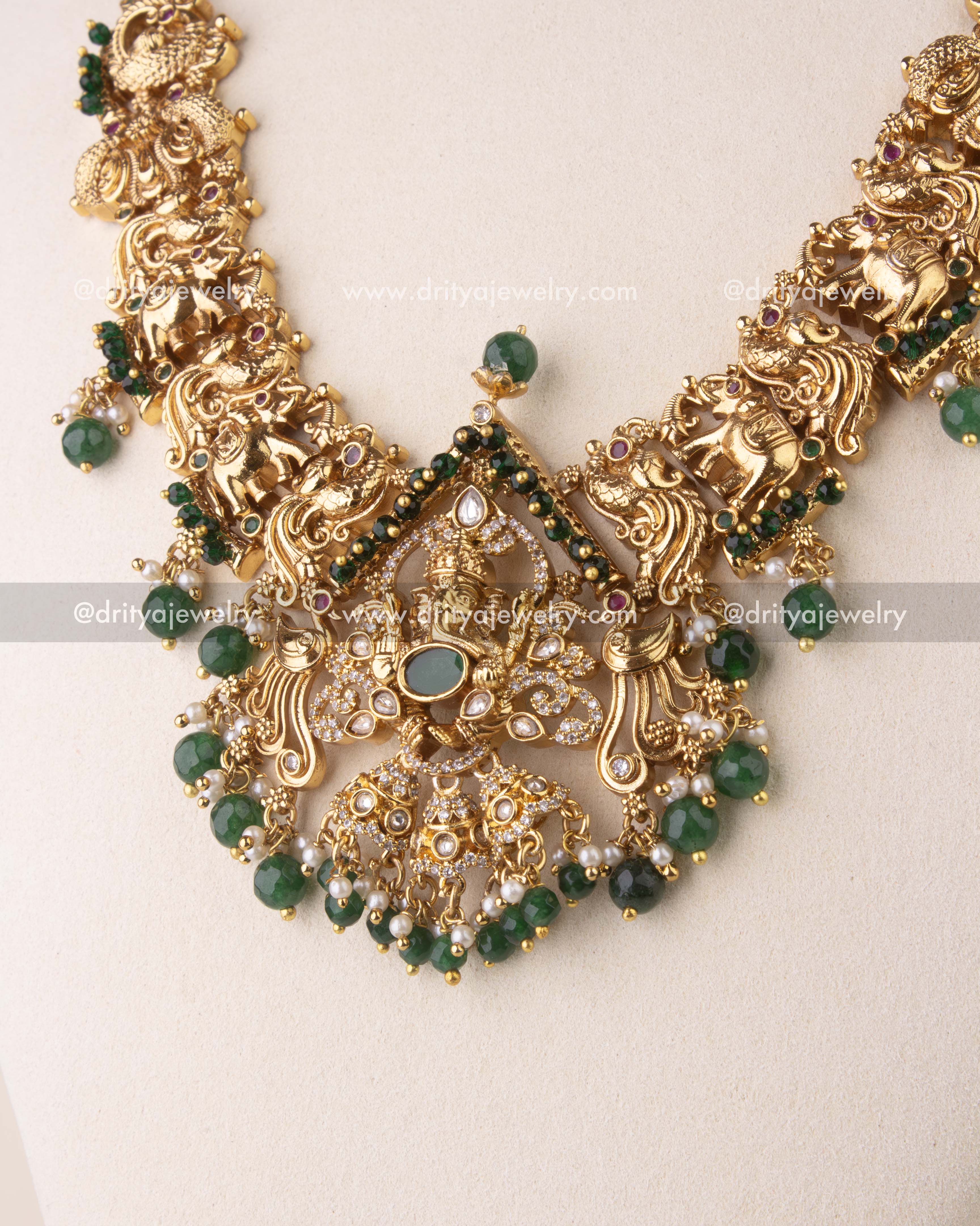 Intricate Ganesha temple pendant with CZ stones and green bead detailing.