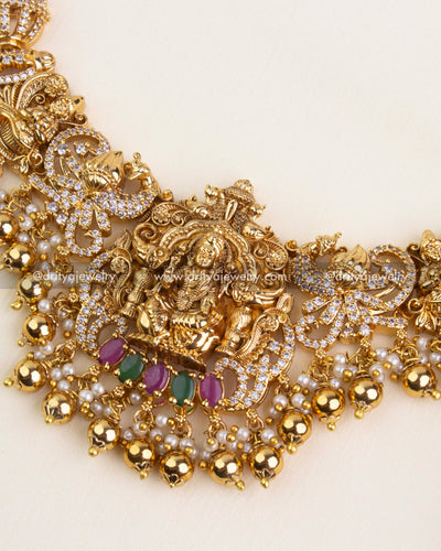 Detailed view of Nakshi necklace with Lakshmi figure, gold ball drops, and intricate carvings.