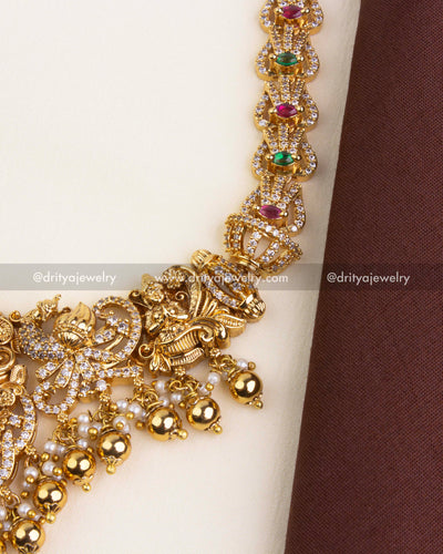 Detailed view of Nakshi necklace with Lakshmi figure, gold ball drops, and intricate carvings.