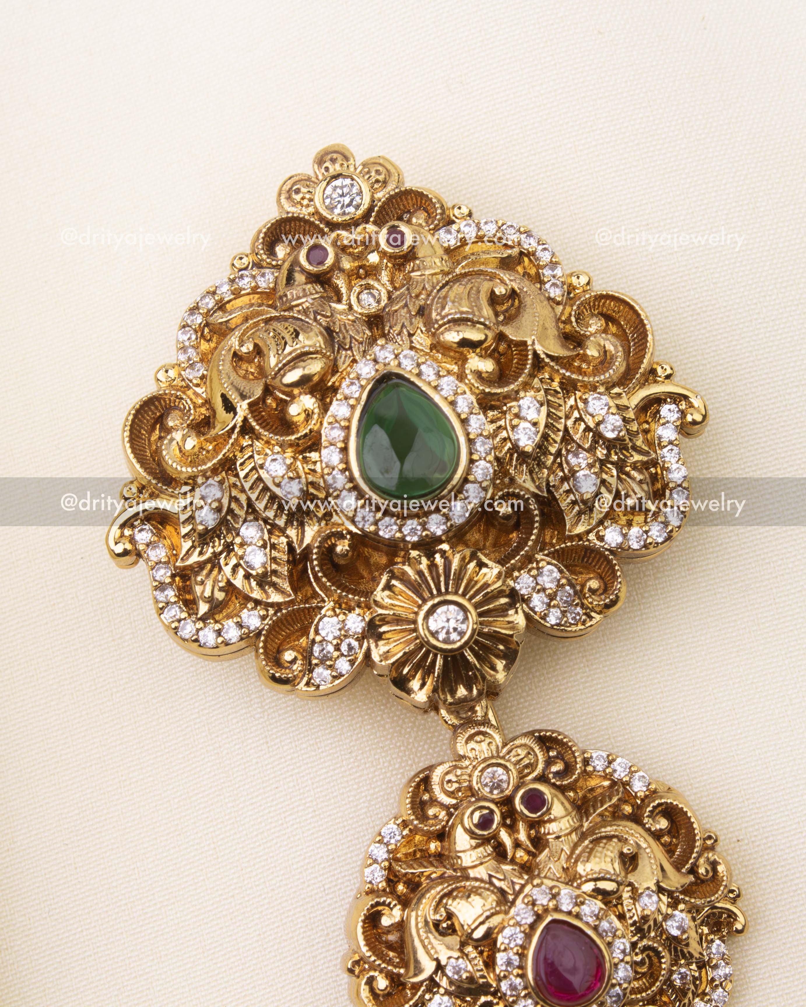 Detailed close-up of emerald green stone Jada Billa with floral nakshi design.