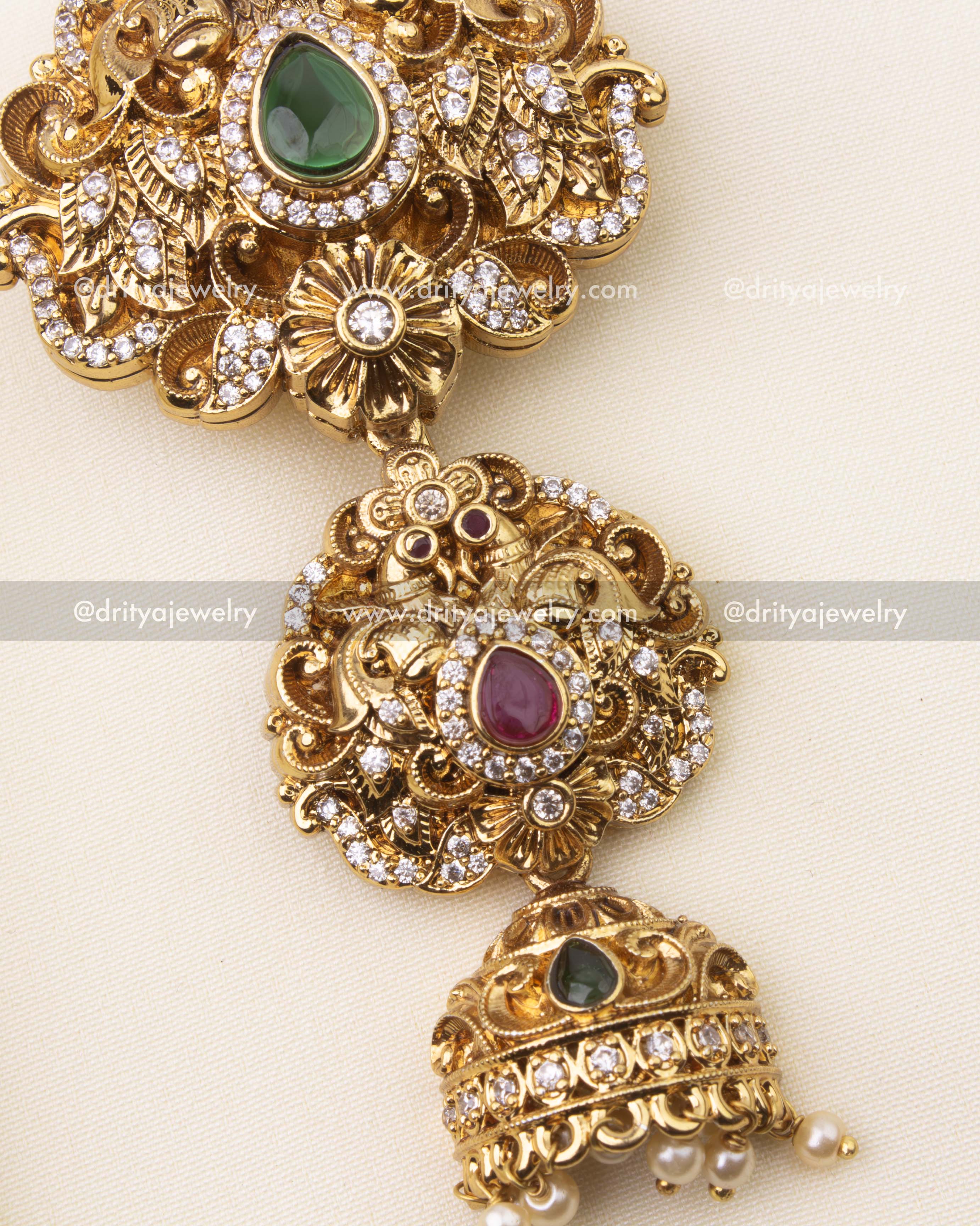 Detailed close-up of emerald green stone Jada Billa with floral nakshi design.