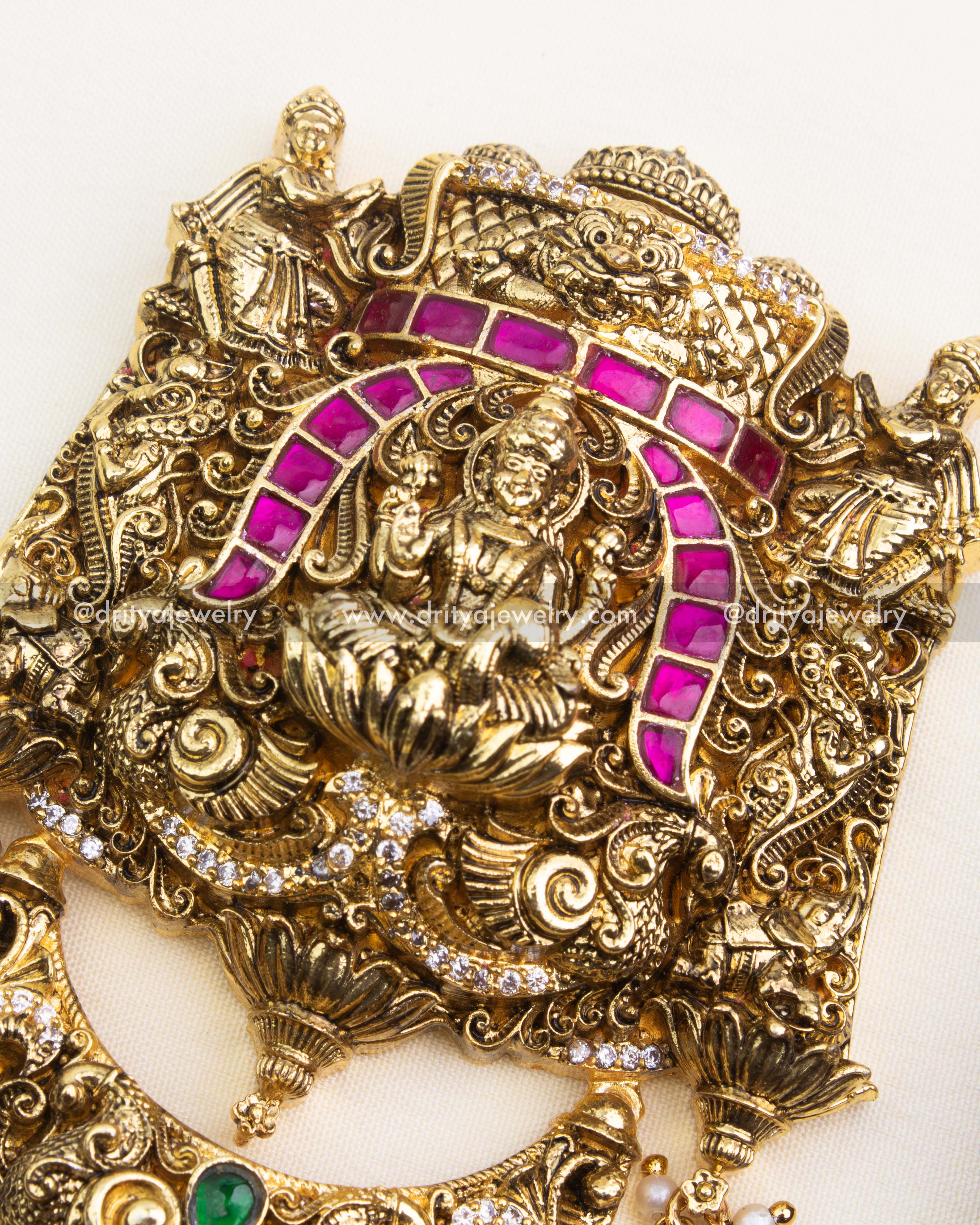 Detailed Nakshi carvings and green kemp stone embellishments on antique polished Jada Billa.