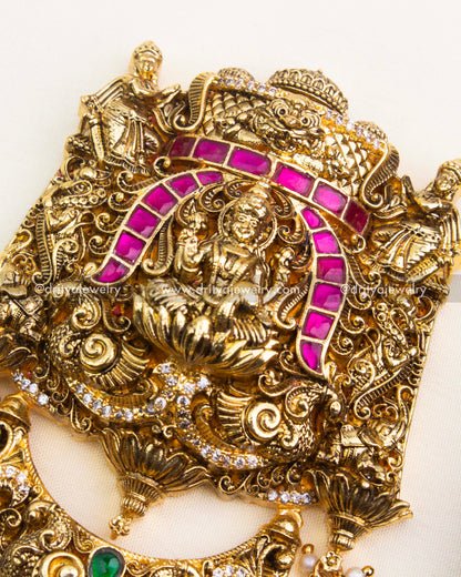 Detailed Nakshi carvings and green kemp stone embellishments on antique polished Jada Billa.