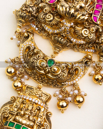 Detailed Nakshi carvings and green kemp stone embellishments on antique polished Jada Billa.