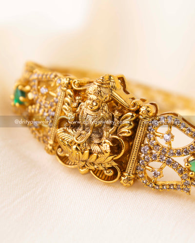Detailed view of Nakshi kada featuring CZs and emerald green stonework