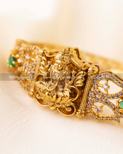 Detailed view of Nakshi kada featuring CZs and emerald green stonework