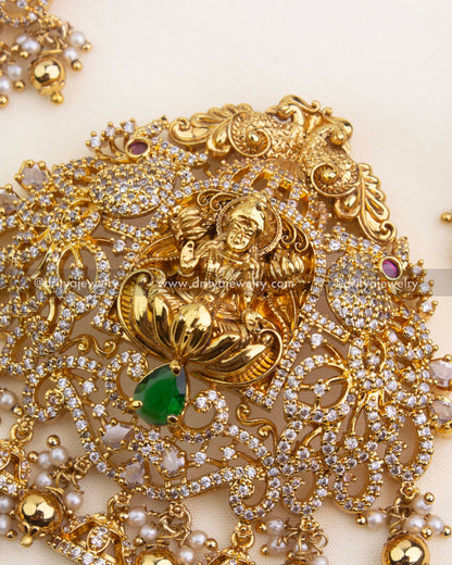 Intricate Lakshmi pendant with CZ detailing, emerald green center stone, and pearl clusters.