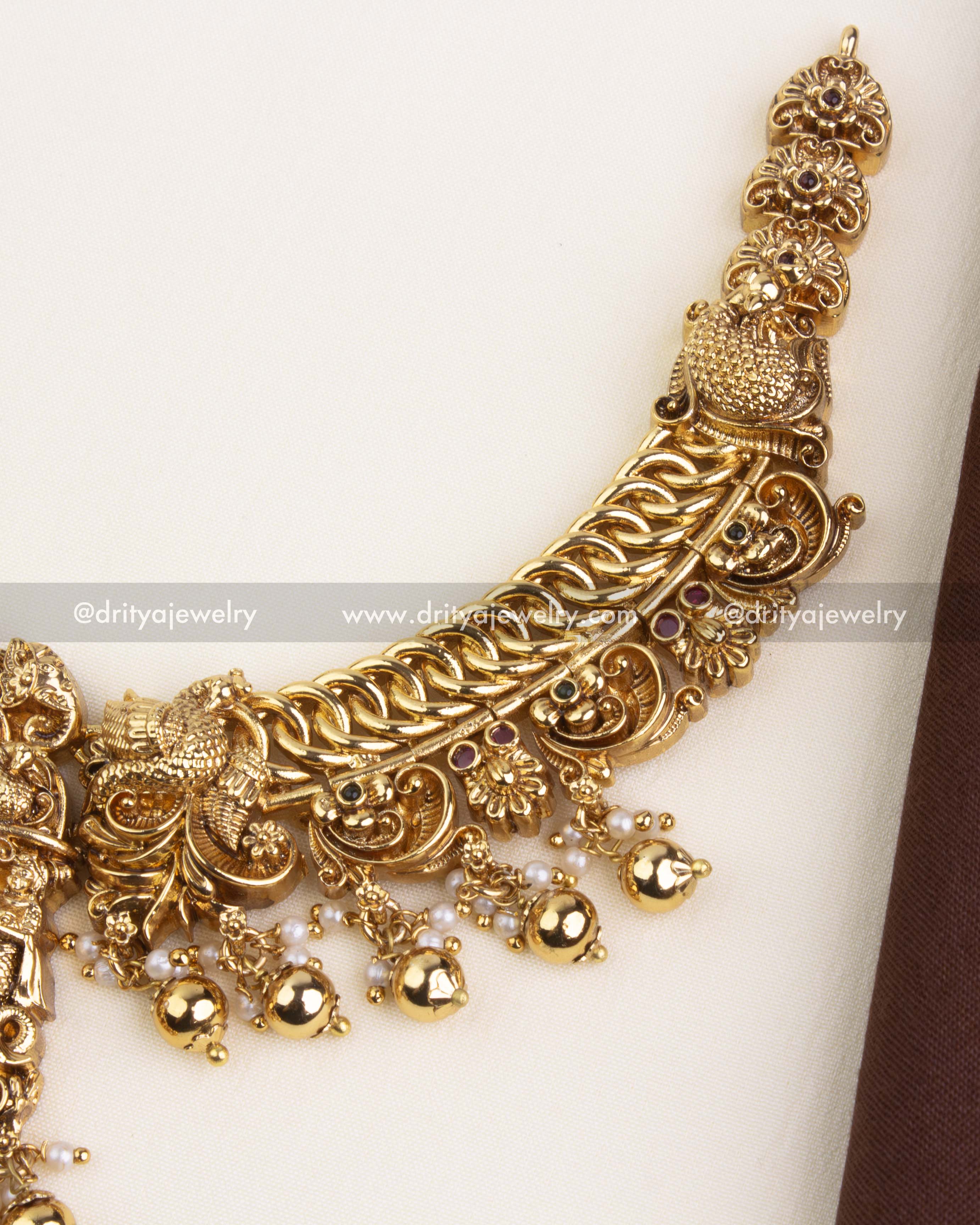 Intricate close-up of the necklace chain featuring interlinked design and antique temple motifs.