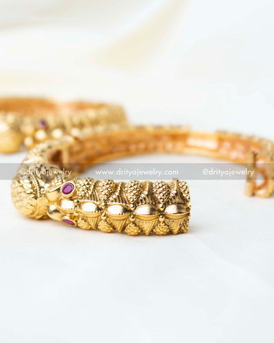 Detailed view of the openable kada with traditional carvings and ruby embellishments.