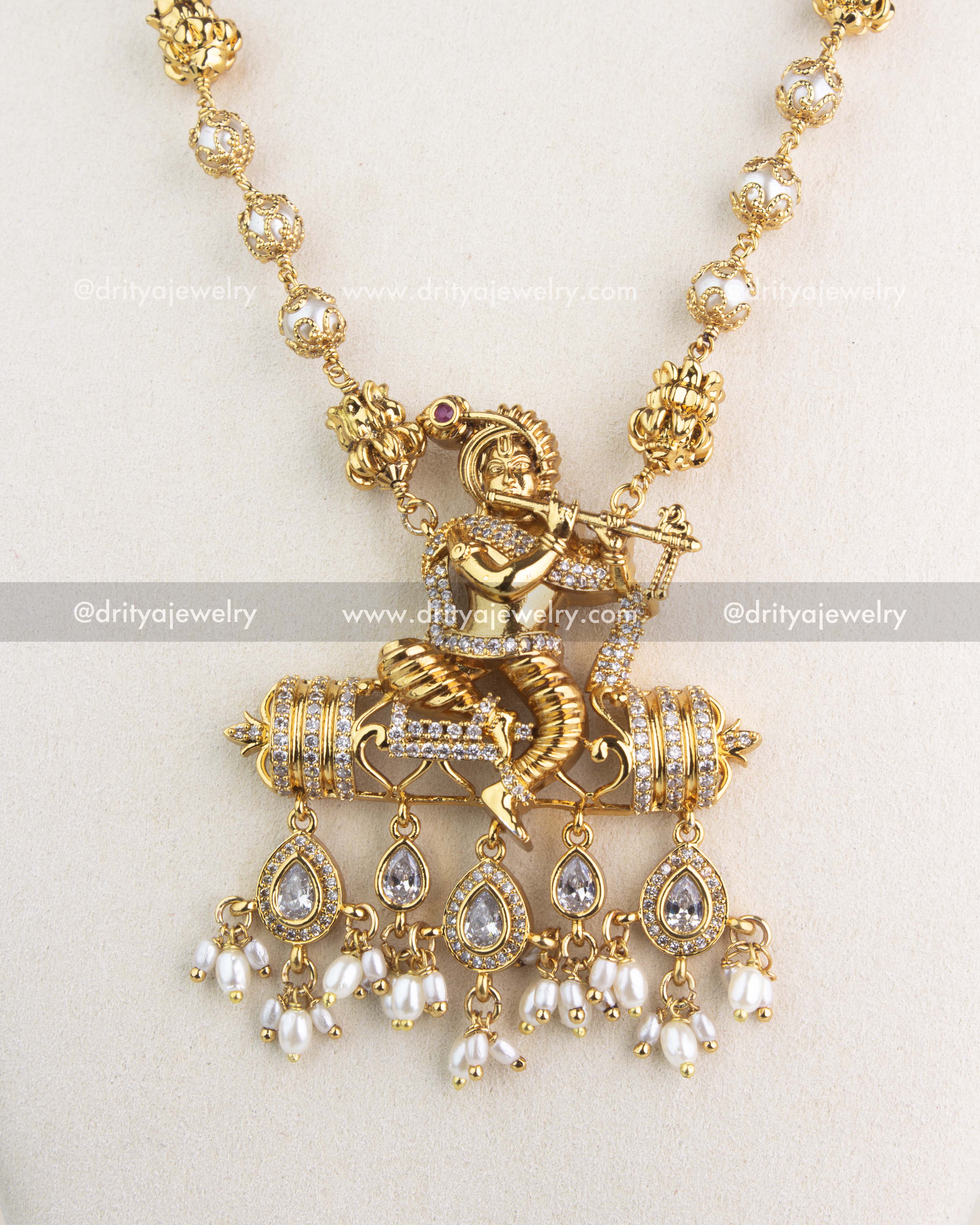 Intricate Krishna pendant design with CZ stones and dangling pearl drops.