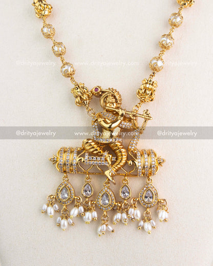 Intricate Krishna pendant design with CZ stones and dangling pearl drops.