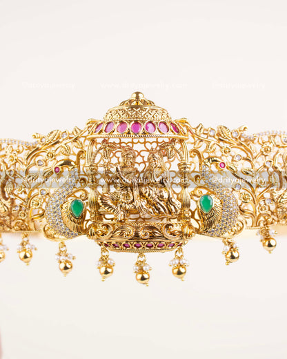 Detailed view of Krishna with flute under pink-studded canopy and gold filigree frame.