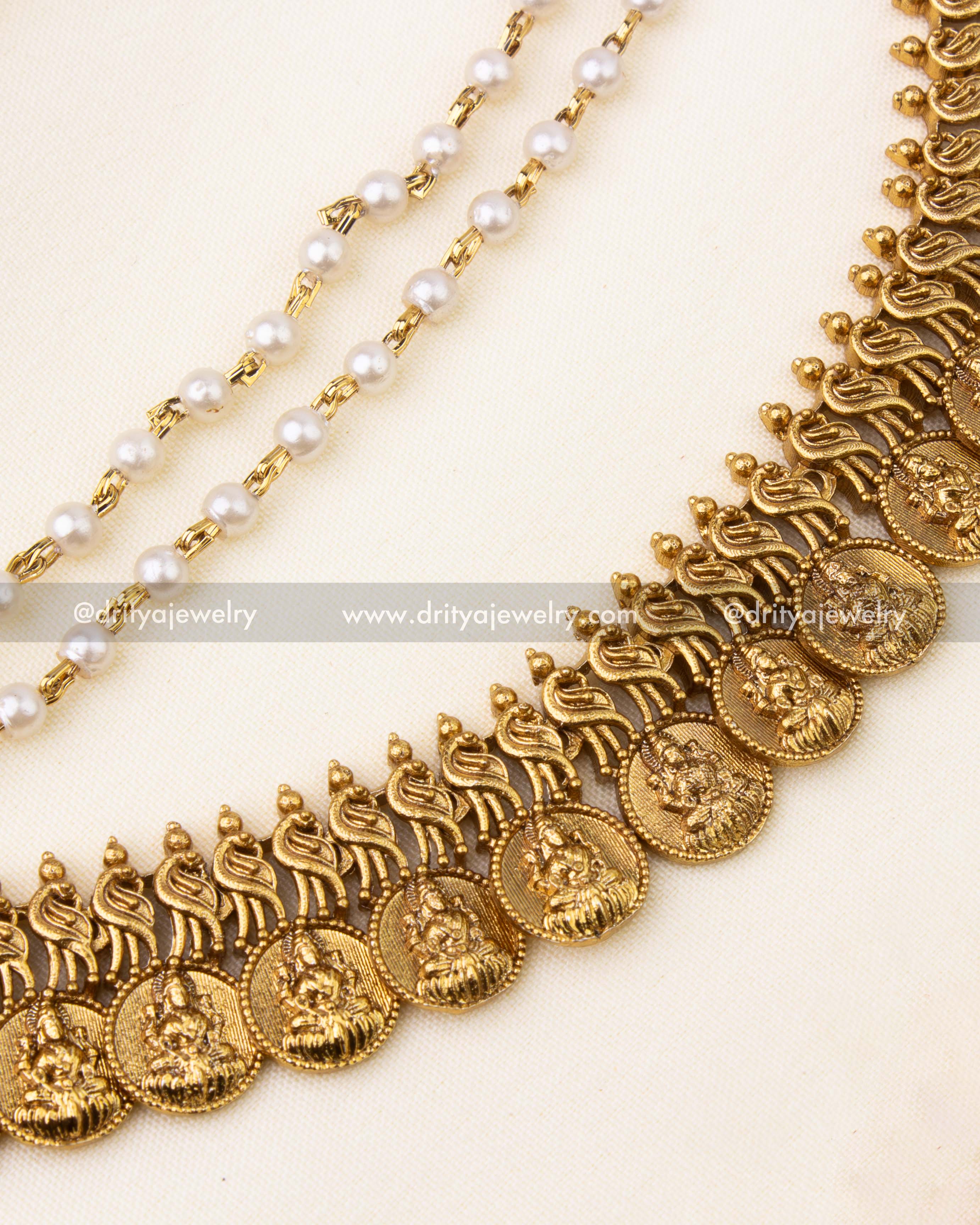 Detailed Lakshmi coin motifs with antique polish and pearl-beaded chains in champa swaralu.