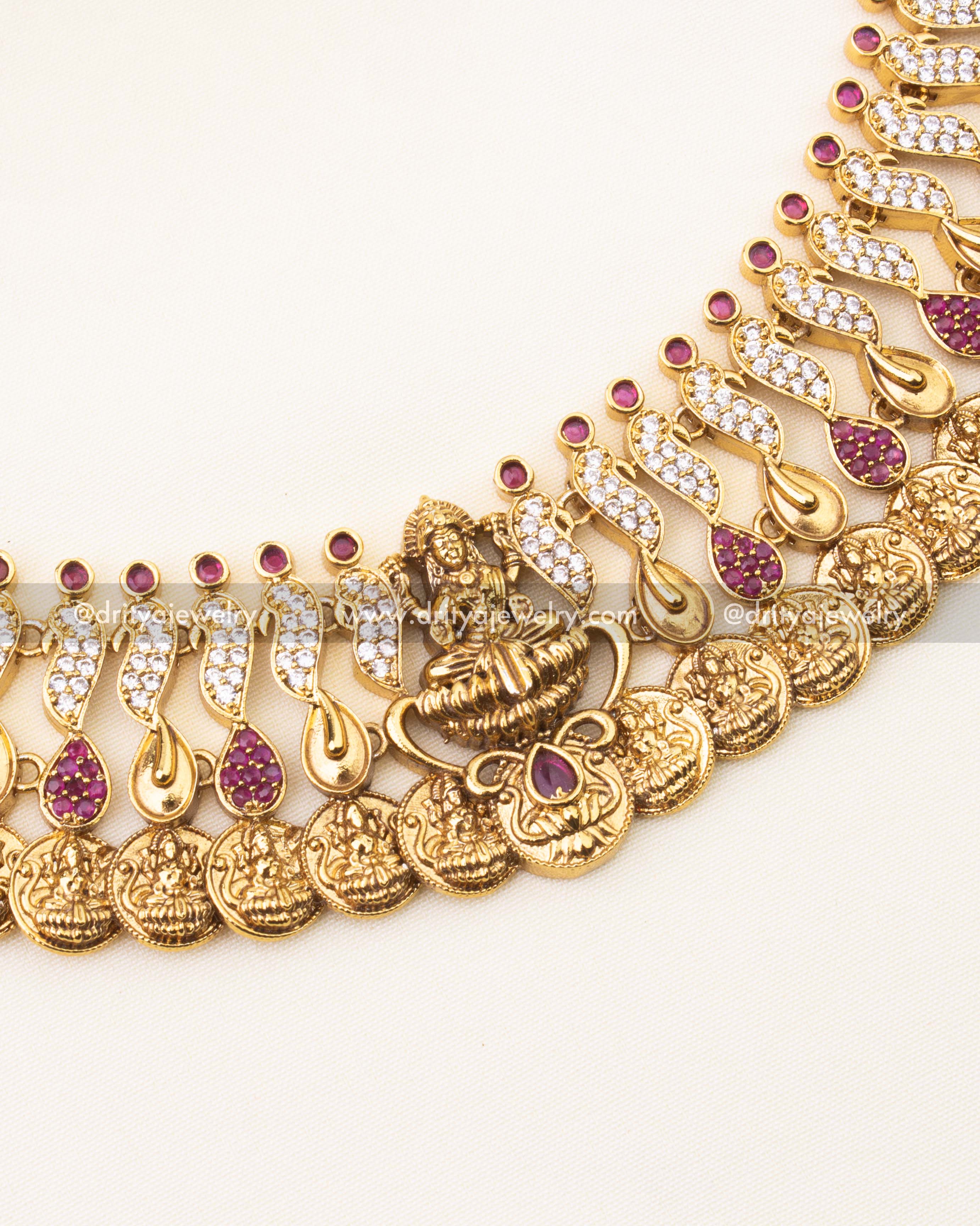 Detailed view of Kasulu necklace with ruby and CZ paisley motifs and Lakshmi coin engravings.