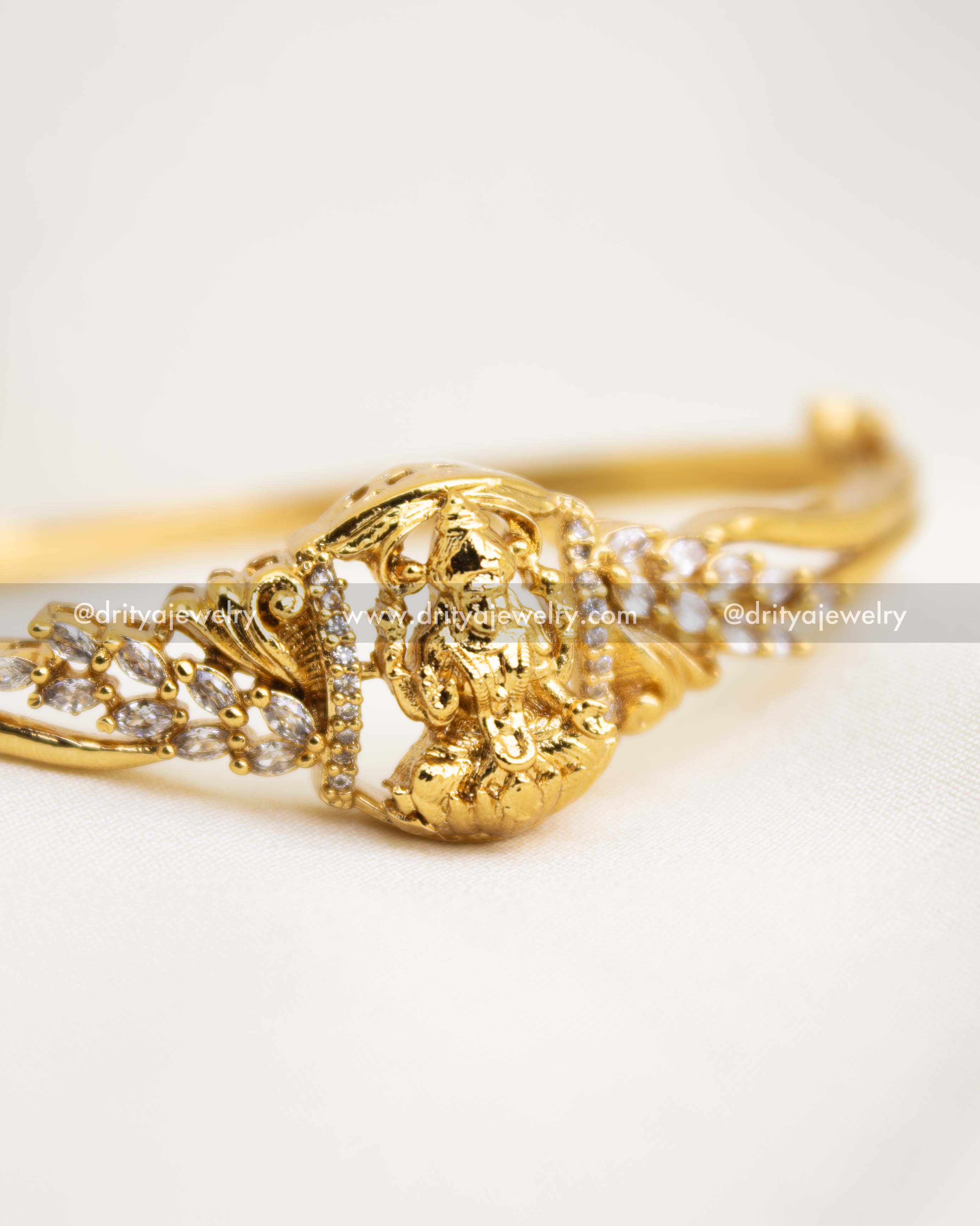 Detailed view of premium temple kada with Lakshmi idol and CZ stones in antique finish.