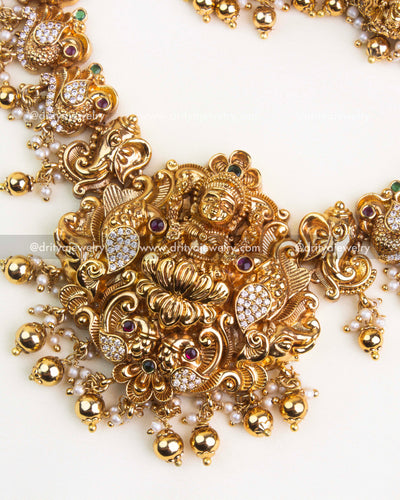 Lakshmi pendant with peacocks, floral detailing, and pearl-gold bead hangings in nakshi jewelry.