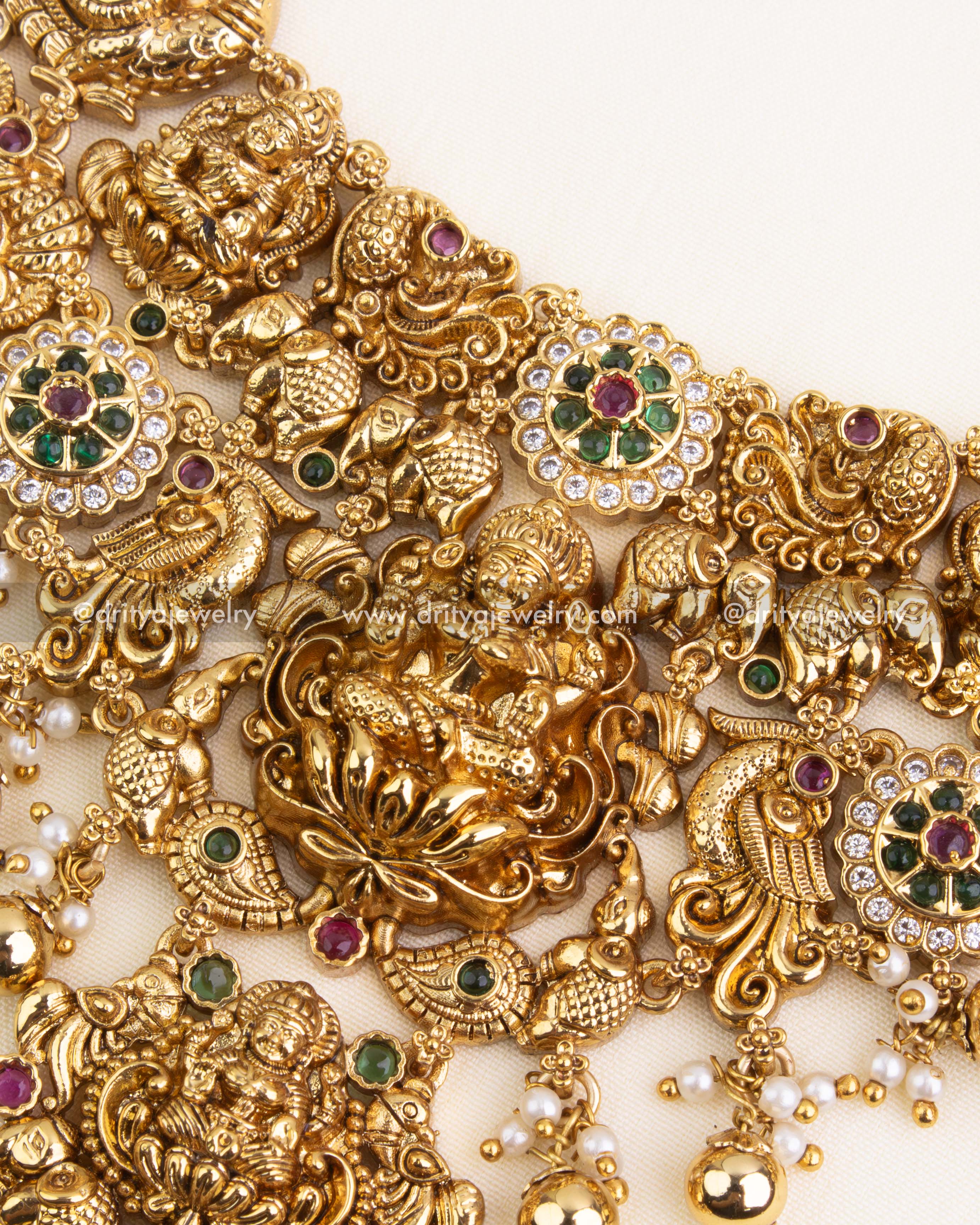Detailed view of central Lakshmi Devi pendant with ruby-emerald CZ stone clusters and temple-inspired carvings.