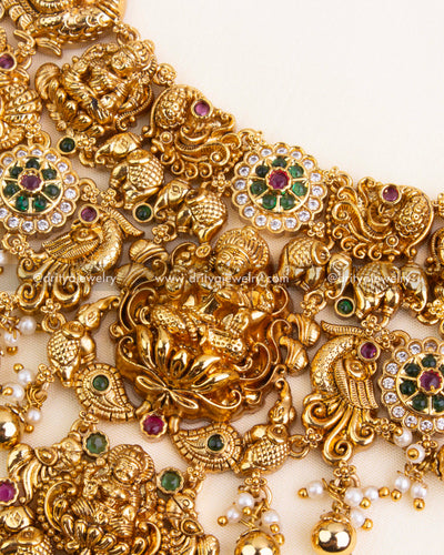 Detailed view of central Lakshmi Devi pendant with ruby-emerald CZ stone clusters and temple-inspired carvings.
