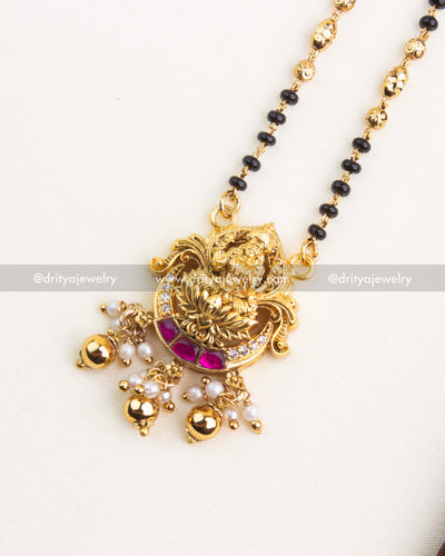 Traditional mangalsutra necklace with Goddess Lakshmi pendant, kemp stones, pearls, and antique gold finish.