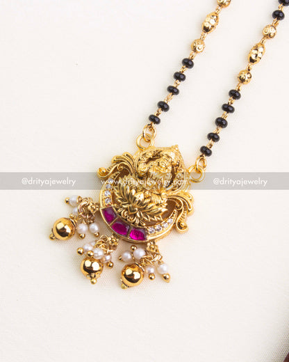 Traditional mangalsutra necklace with Goddess Lakshmi pendant, kemp stones, pearls, and antique gold finish.