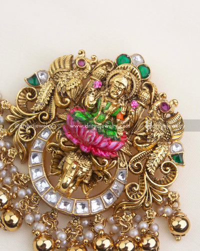 Detailed close-up of temple pendant with hand-painted meenakari work, peacock motifs, and antique gold nakshi carvings.