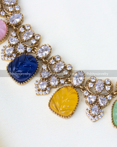 Close-up view of multicolour carved stones and AD embellishments on a premium necklace.