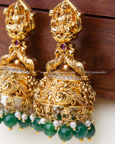 Close-up view highlighting the goddess carving, nakshi peacock motifs, and green beads on big temple Jhumka.