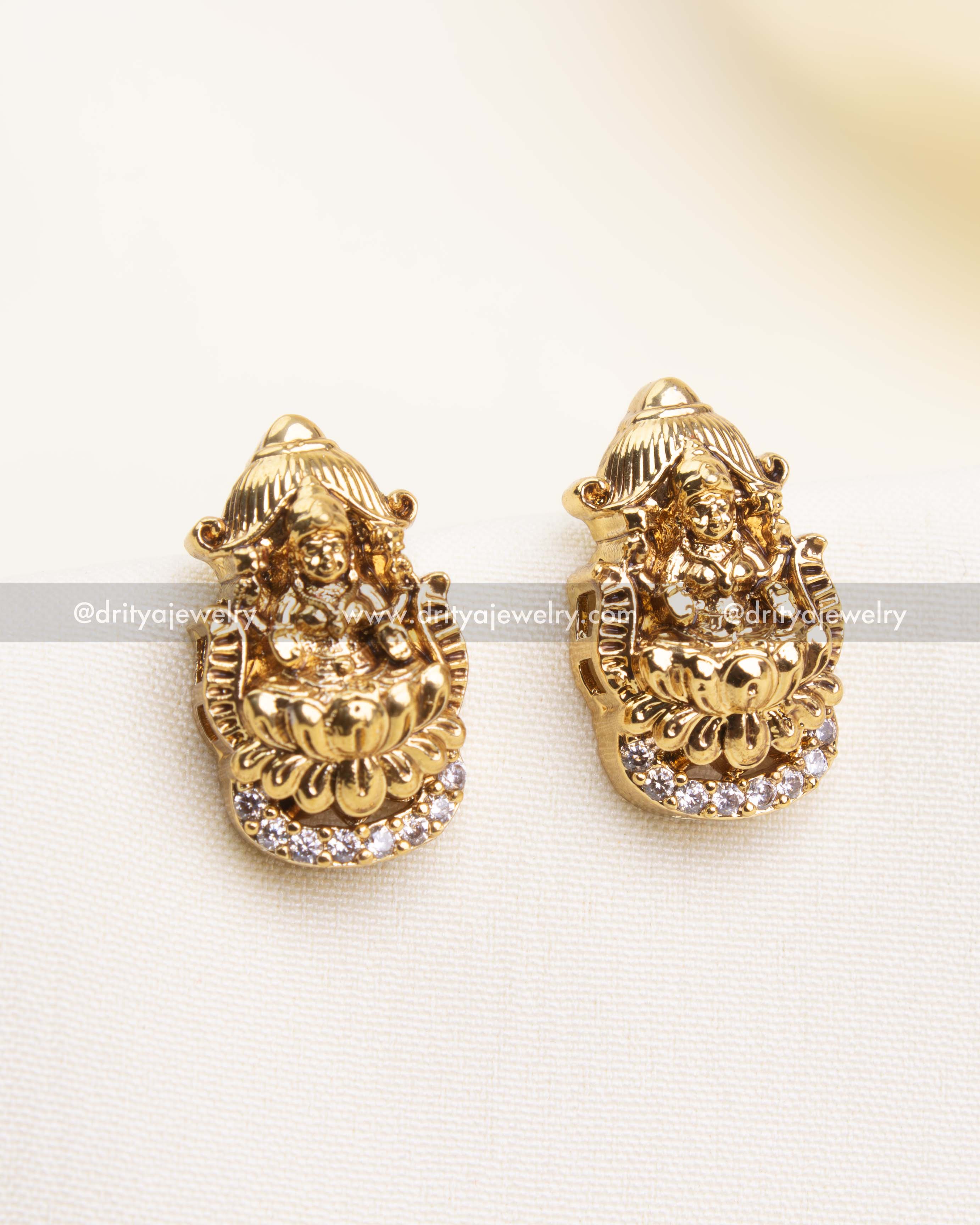 Close-up of traditional Lakshmi Nakshi stud earrings with sparkling CZ stone border.