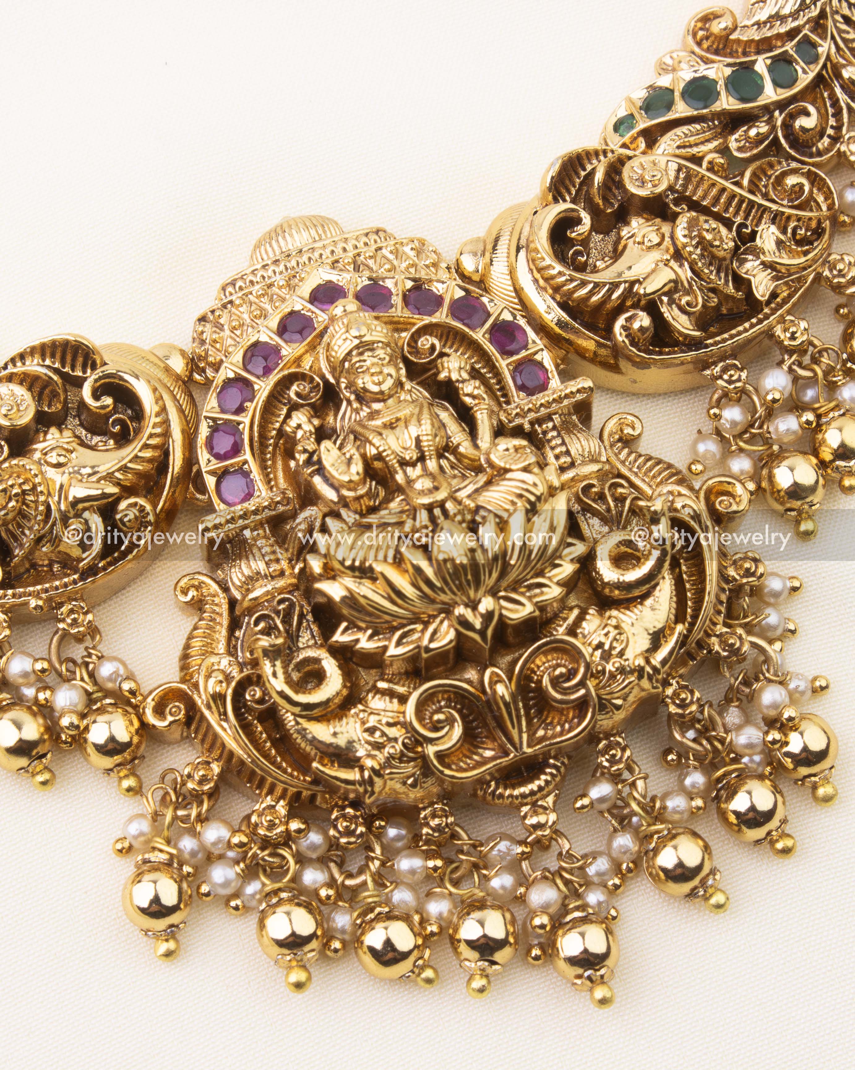 Detailed view of Lakshmi centerpiece with ruby and emerald Kemp stones on nakshi short necklace.
