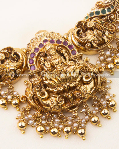 Detailed view of Lakshmi centerpiece with ruby and emerald Kemp stones on nakshi short necklace.