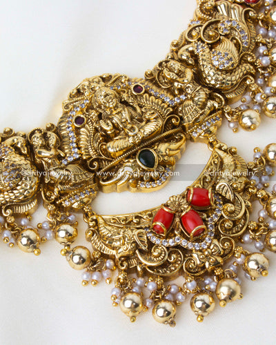 Detailed close-up of Nakshi necklace featuring deity motifs and coral beads.