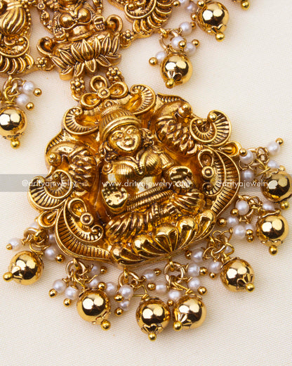 Detailed view of intricate nakshi carvings with ruby and green stone accents on Kanti short necklace.