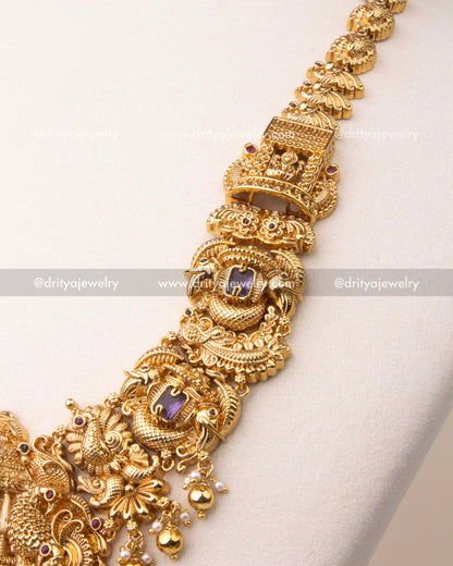 Intricate nakshi carvings with peacock motifs and violet stones on temple necklace chain.