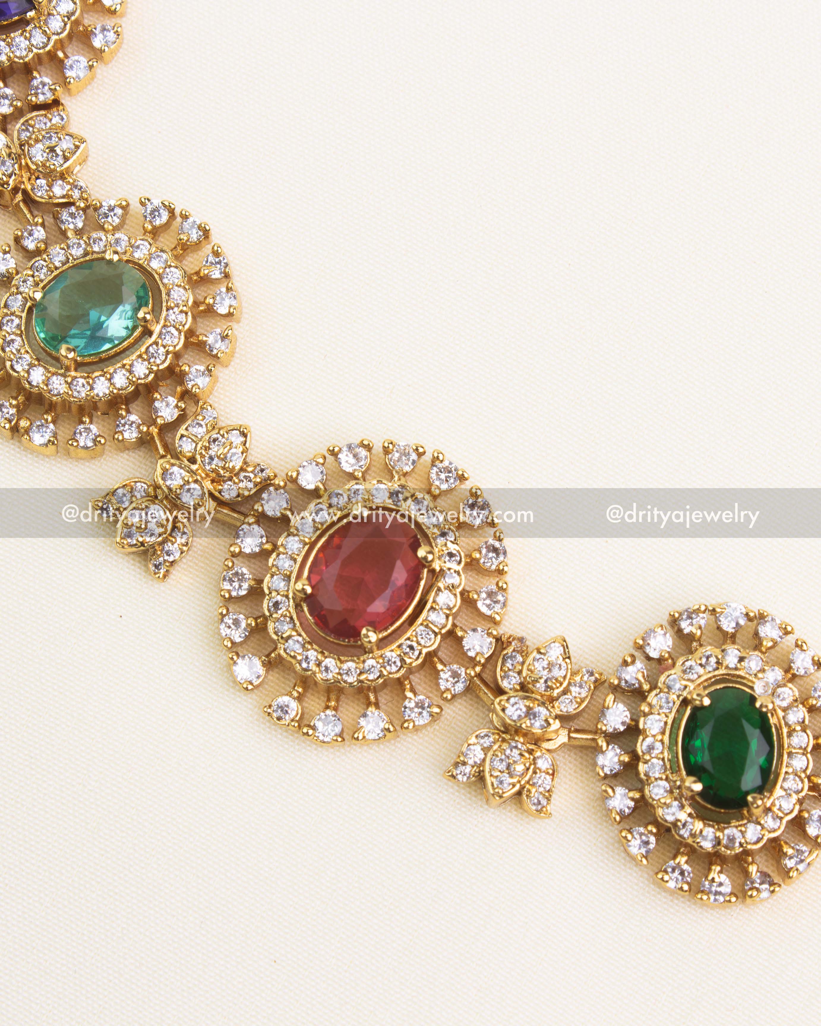 Detailed close-up of multicolor navaratna stones surrounded by CZ halo design in a short gold necklace.