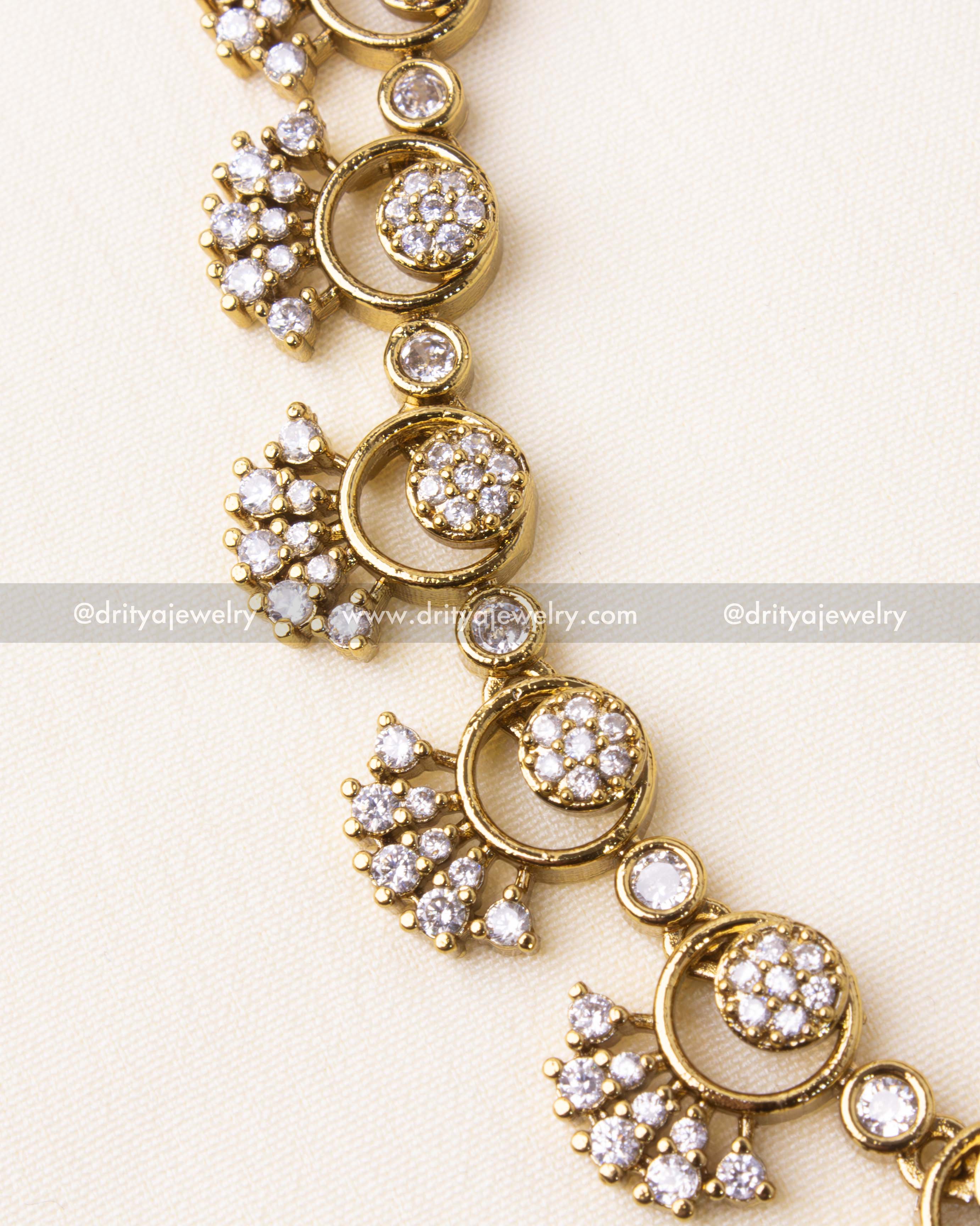 Intricate crescent motifs and sparkling CZ stones in a gold-plated necklace.