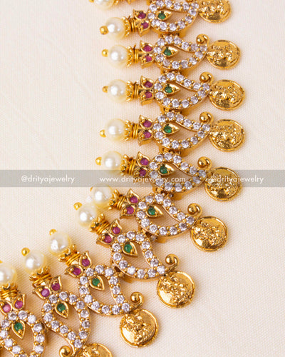 Exquisite mango-shaped motifs with shimmering CZ stones, pearls, and ruby-emerald accents.