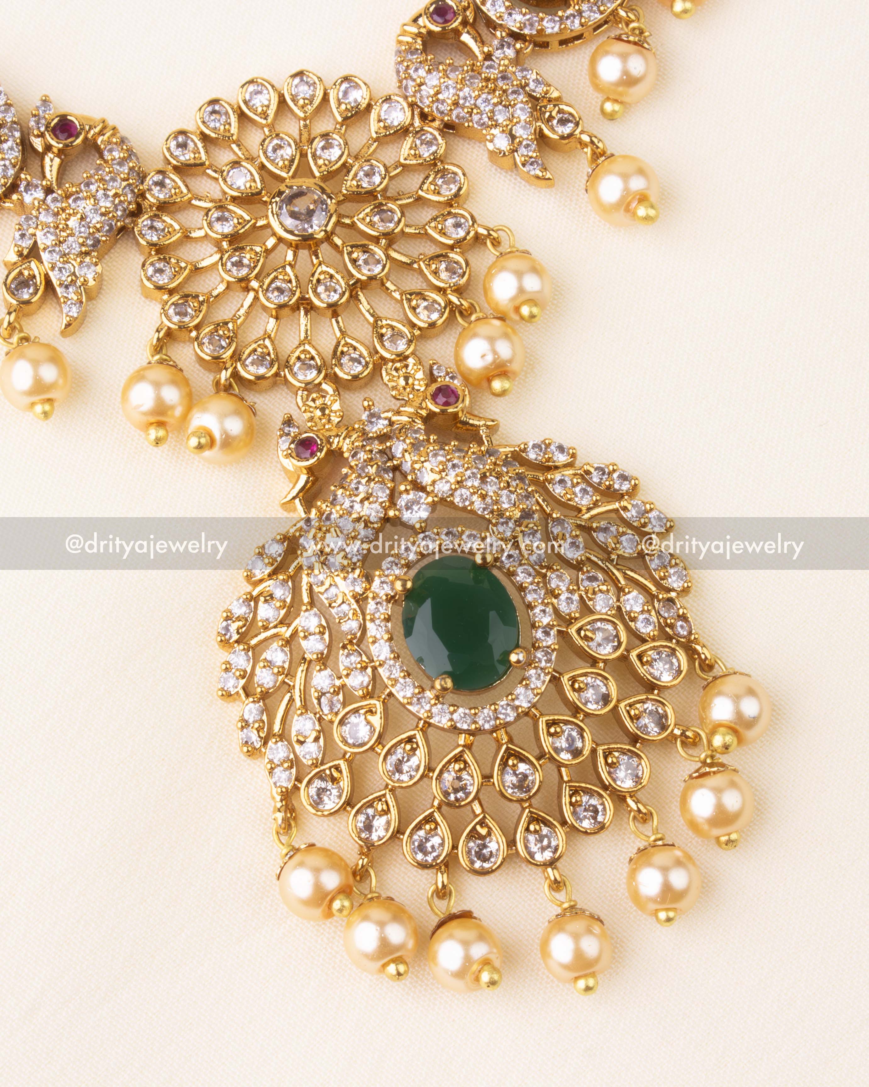 Detailed view of peacock motif necklace pendant with CZ stones and pearl hangings.