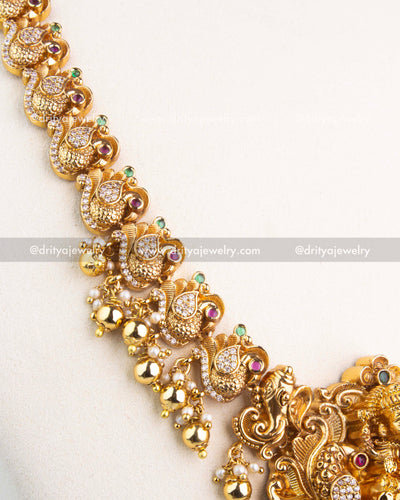 Detailed peacock motif chain with ruby and emerald highlights in temple jewelry long necklace.