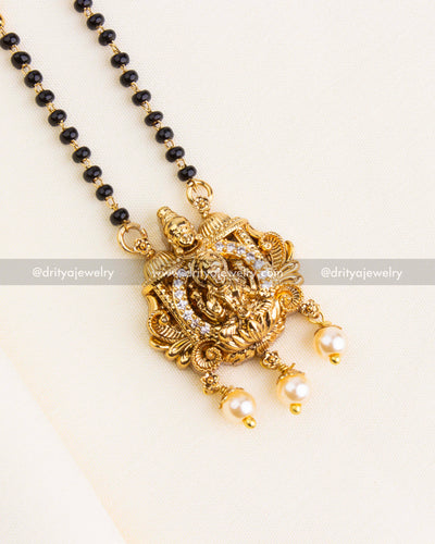 Detailed Lakshmi Devi pendant with CZ stones and pearl drops on black beads necklace.